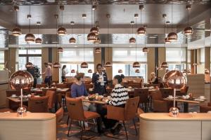 people sitting at tables in a restaurant at Maritim Hotel Ingolstadt in Ingolstadt