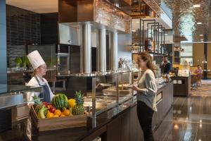 two women standing in a kitchen preparing food at Maritim Hotel Ingolstadt in Ingolstadt