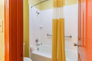 a bathroom with a tub and a shower curtain at The Residency Inn in Galveston