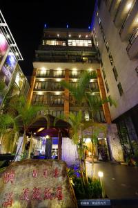 a tall building with palm trees in front of it at Einhan Resort in Yuchi