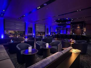 a bar with blue lighting and couches and tables at Maritim Hotel Ingolstadt in Ingolstadt