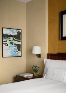 a bedroom with a bed and a table with a lamp at The Beaumont Mayfair in London