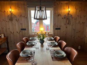 una sala da pranzo con un lungo tavolo e sedie in pelle di Ingrid Rorbu, Å i Lofoten a Å