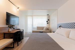 1 dormitorio con cama, escritorio y sofá en Magnolia Hotel - Adults Only, en Salou