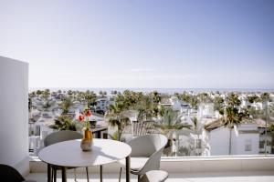 THE FLAG HOTEL Marbella, Estepona Adult Recommended في إِستيبونا: غرفة مع طاولة وكراسي وإطلالة على المدينة