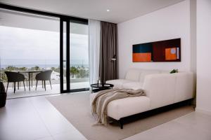 THE FLAG HOTEL Marbella, Estepona Adult Recommended في إِستيبونا: غرفة معيشة مع أريكة بيضاء وطاولة