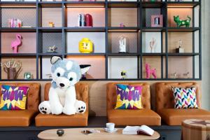 a teddy bear sitting on chairs in a waiting room at Moxy Rust in Rust