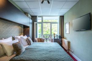 a hotel room with a bed and a flat screen tv at Hotel Atlantis Amsterdam in Amsterdam