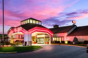 een groot gebouw met een roze zonsondergang op de achtergrond bij Red Roof Inn PLUS+ & Suites Knoxville West - Cedar Bluff in Knoxville