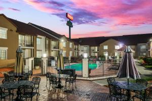 een hotelpatio met tafels en stoelen en een zwembad bij Red Roof Inn PLUS+ & Suites Knoxville West - Cedar Bluff in Knoxville