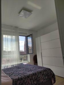 a bedroom with a bed and a window at Apartman Waldy in Osijek