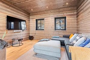 uma sala de estar com um sofá e uma mesa em Rindabakkane Lodge em Sogndal