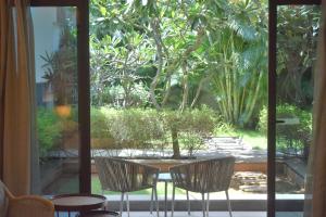 a patio with two chairs and a table and a window at Sheraton Grand Chennai Resort & Spa in Mahabalipuram