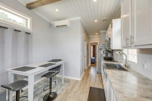 a kitchen with white cabinets and a counter with stools at Community Pool and Hot Tub Austin Tiny Home! in Austin