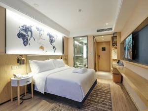 Кровать или кровати в номере Kyriad Marvelous Hotel Suzhou Guanqian Street and Shiquan Street