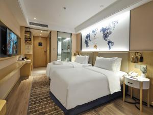 Кровать или кровати в номере Kyriad Marvelous Hotel Suzhou Guanqian Street and Shiquan Street