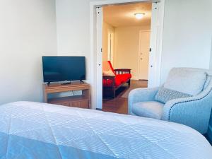 a bedroom with a bed and a tv and a chair at South Zion Inn and Suites in Hildale