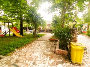 a park with a yellow trash can and a playground at Paşa Restaurant & Pansiyon in Kemer