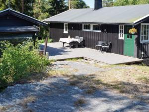 a house with a wooden deck in front of it at Holiday home Halden IV in Halden