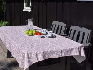 a table with a pink table cloth and fruit on it at Holiday home Halden IV in Halden