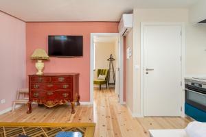 a living room with a red dresser and a tv on a wall at JOIVY Flats next to Rossio Square and main Lisbon attractions in Lisbon