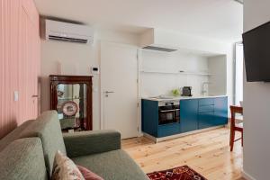 a living room with a couch and a kitchen at JOIVY Flats next to Rossio Square and main Lisbon attractions in Lisbon