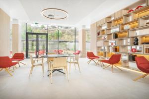 a dining room with red chairs and a table at Moov Hotel Lisboa Oriente in Lisbon