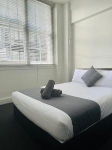 een slaapkamer met een groot bed en een telefoon. bij Gamma Hotel in Auckland