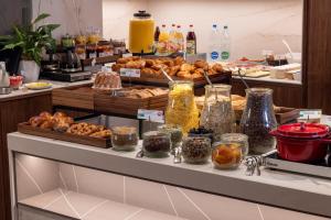 a buffet line with various pastries and other food items at Hôtel Gutenberg in Strasbourg