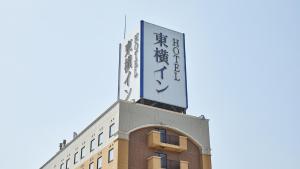 米泽市Toyoko Inn Yonezawa Ekimae的上面有标志的建筑