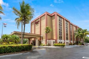 ein Hotel mit Palmen auf einem Parkplatz in der Unterkunft Hampton Inn Miami-Airport West in Miami