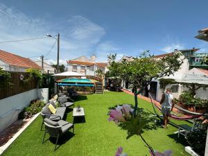 Ein Mann steht in einem Garten mit Gras in der Unterkunft Vila Maria Mix Dorm by HOST-POINT in Costa da Caparica