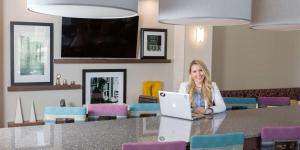 a woman sitting at a table with a laptop at Hampton Inn & Suites - Knoxville Papermill Drive, TN in Knoxville