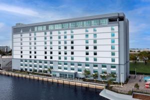 a rendering of a white building next to a body of water at Tru By Hilton Miami Airport South Blue Lagoon, Fl in Miami