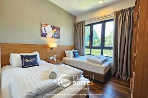 2 łóżka w pokoju hotelowym z oknem w obiekcie Onsen Premium Suites @ Tambun Ipoh w mieście Ipoh