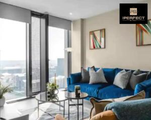 Mercian Luxury Aparthotel - Birmingham City Centre - Your Perfect Stay - 24 Hour Gym Rooftop Terrace Cinema Room في برمنغهام: أريكة زرقاء في غرفة المعيشة مع نافذة كبيرة