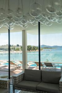 uma sala de estar com um sofá e vista para a água em Dedaj Resort - Villa Tina em Zadar