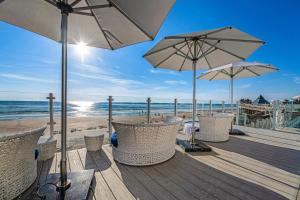 a wooden deck with chairs and umbrellas on the beach at Daytona Grande Oceanfront Resort in Daytona Beach