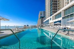 a swimming pool next to the ocean with buildings at Daytona Grande Oceanfront Resort in Daytona Beach