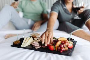 a tray of food on a bed with a plate of food at Sheraton Grand Chennai Resort & Spa in Mahabalipuram