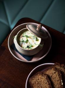 uma tigela de sopa numa mesa com um prato de pão em The Bianconi Inn em Killorglin