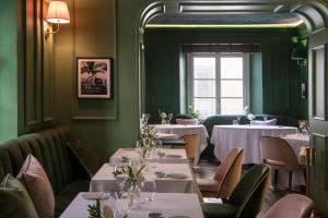 a restaurant with white tables and chairs and a window at Hotel La Gemma in Florence