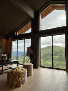 uma sala de estar com janelas grandes e um sofá em Sogndal Chalet em Sogndal