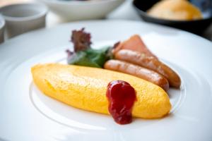 a white plate with a hot dog and ketchup at Asakusa Tobu Hotel in Tokyo