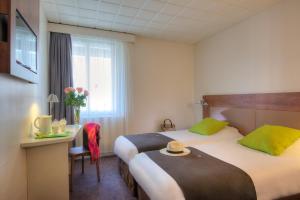 a hotel room with two beds and a table and a window at Campanile Annecy Centre - Gare in Annecy