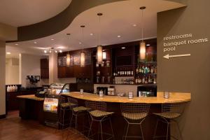 a bar in a restaurant with bar stools at Courtyard by Marriott Boynton Beach in Boynton Beach