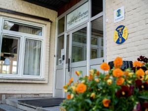 a door of a building with orange flowers in front at Vassbo Vandrarhem in Falun