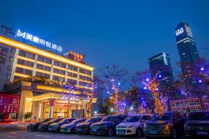 een parkeerplaats met auto's voor een gebouw bij Pazhou Mingyue Resort Hotel Canton Fair Complex Branch in Guangzhou