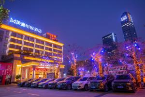 een parkeerplaats met auto's voor een gebouw bij Pazhou Mingyue Resort Hotel Canton Fair Complex Branch in Guangzhou