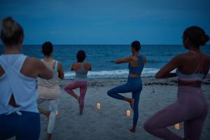 um grupo de pessoas fazendo yoga na praia em Beach Club at The Boca Raton em Boca Raton